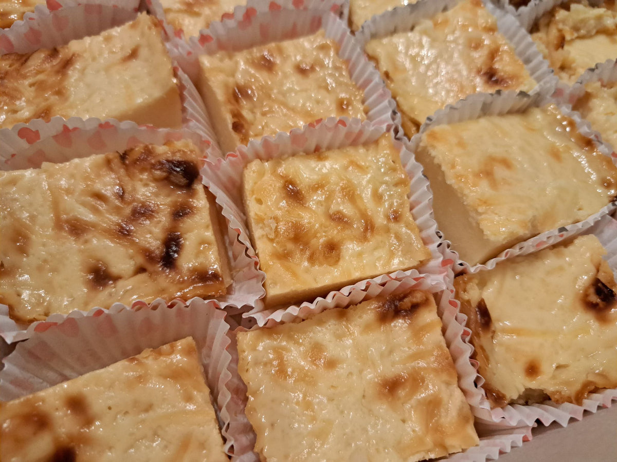 Close-up of cassava cake squares with caramelised tops in paper liners