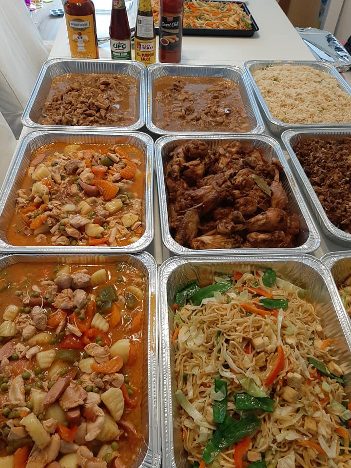 Filipino party buffet with chicken adobo among assorted catering trays