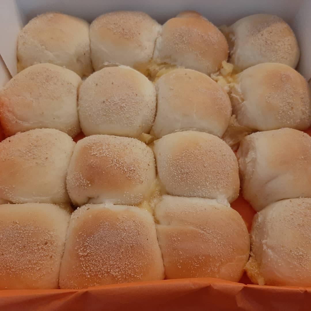 Tray of freshly baked cheese pandesal with pale golden tops
