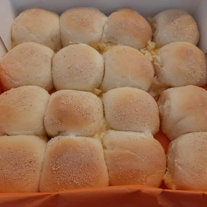 Tray of freshly baked cheese pandesal with pale golden tops