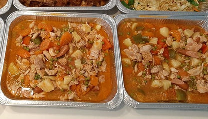 Two foil trays of chicken afritada prepared for catering