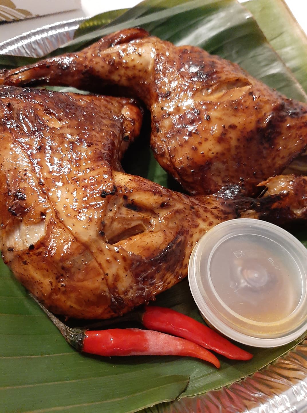 Baked thigh inasal pieces served with chillies and a cup of sauce