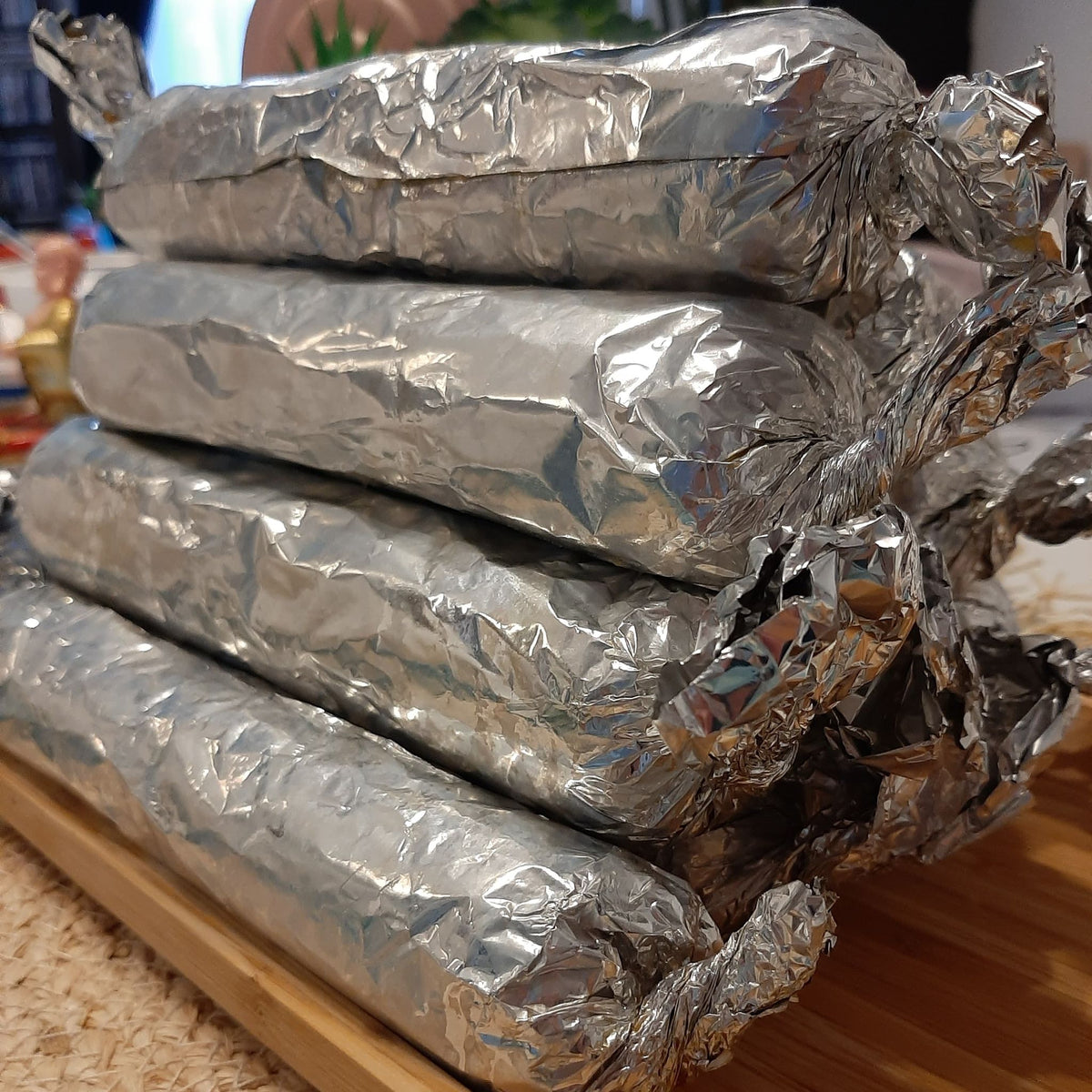 Close-up of foil-wrapped Filipino embutido rolls ready for storage