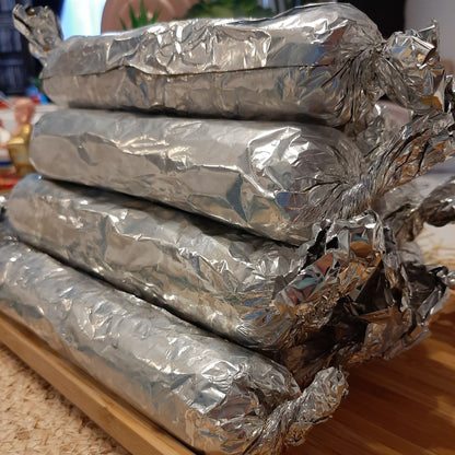 Close-up of foil-wrapped Filipino embutido rolls ready for storage
