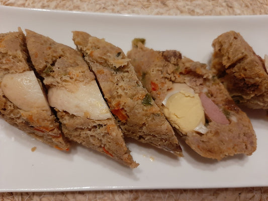 Sliced Filipino embutido with boiled egg, vegetables and sausage filling