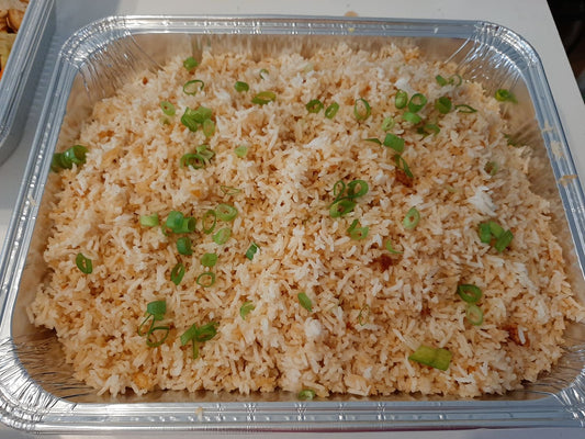 Large tray of Filipino garlic rice topped with spring onions and toasted garlic