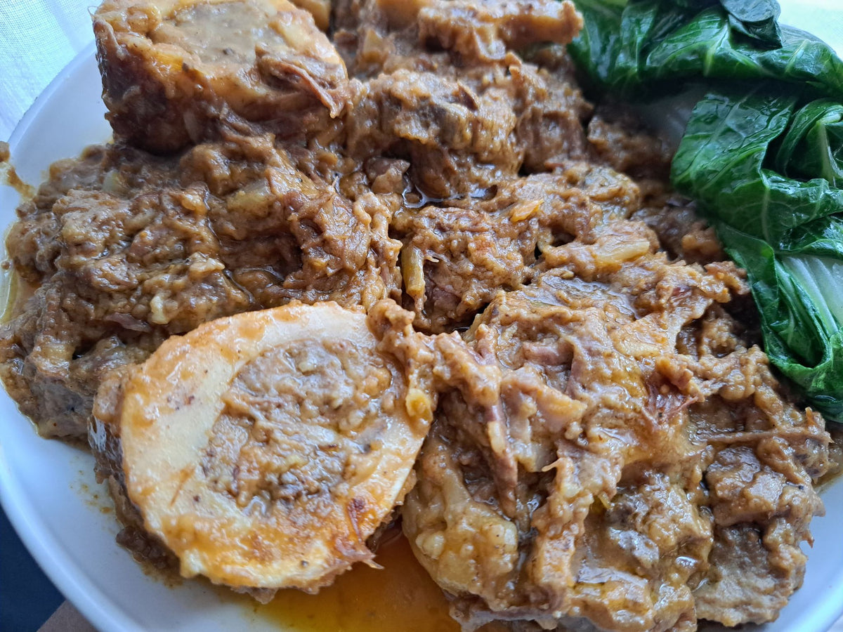 Beef kare-kare with marrow bone and bok choy viewed from the side