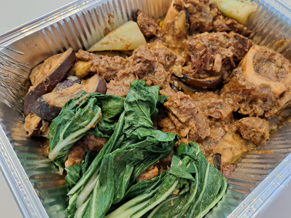 Beef kare-kare served with fresh bok choy and sliced aubergine