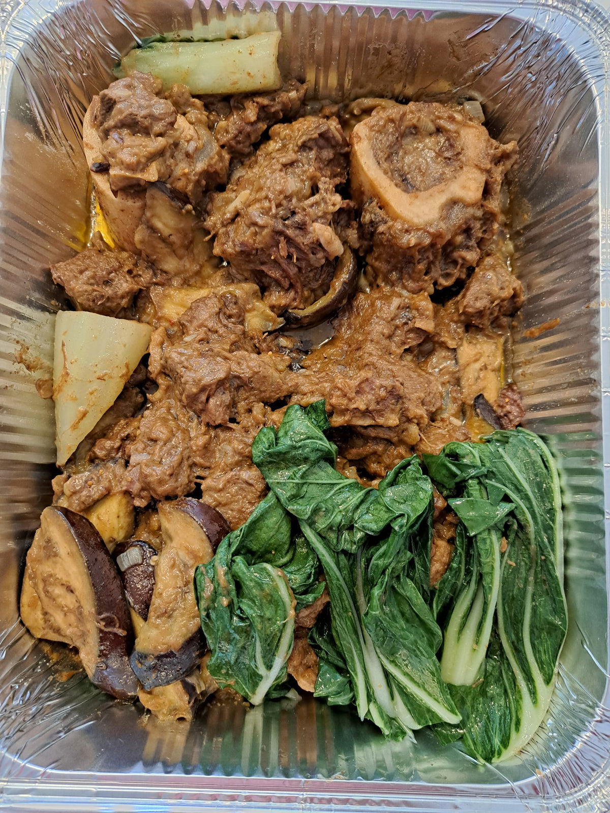 Full tray of beef kare-kare with bok choy and aubergine