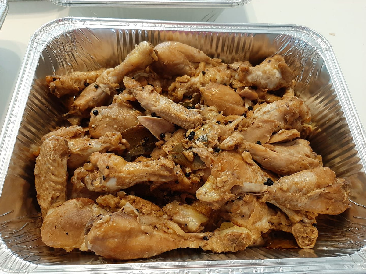 Large tray of chicken adobo pieces cooked in a light savoury sauce