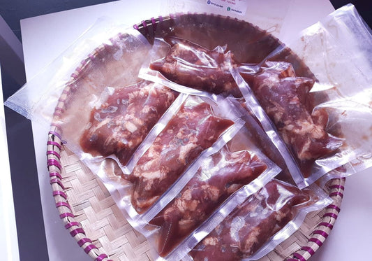 Frozen chicken tocino portions sealed in clear packs on a woven tray