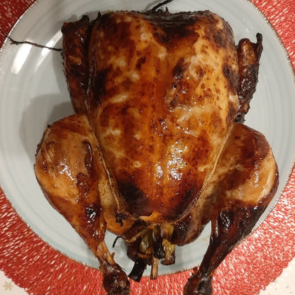 Overhead view of whole lechon manok with evenly roasted golden-brown skin