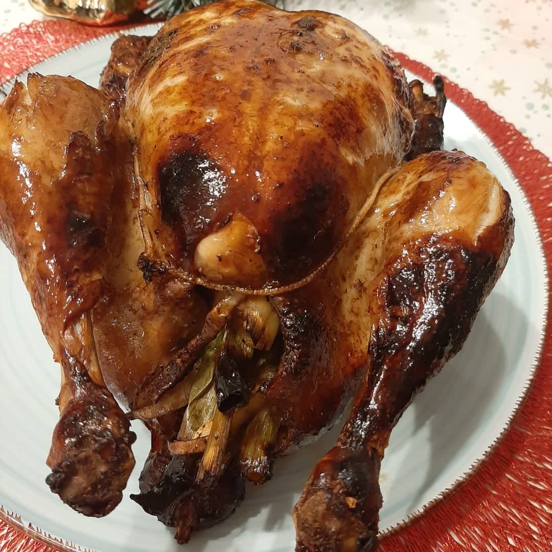Whole Filipino lechon manok filled with aromatic lemongrass on a serving plate