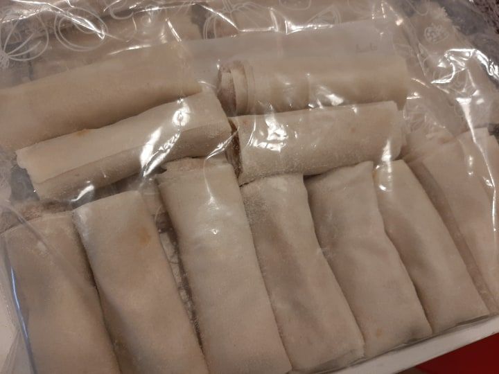 Close-up of uncooked chicken mini lumpia wrapped and ready to fry