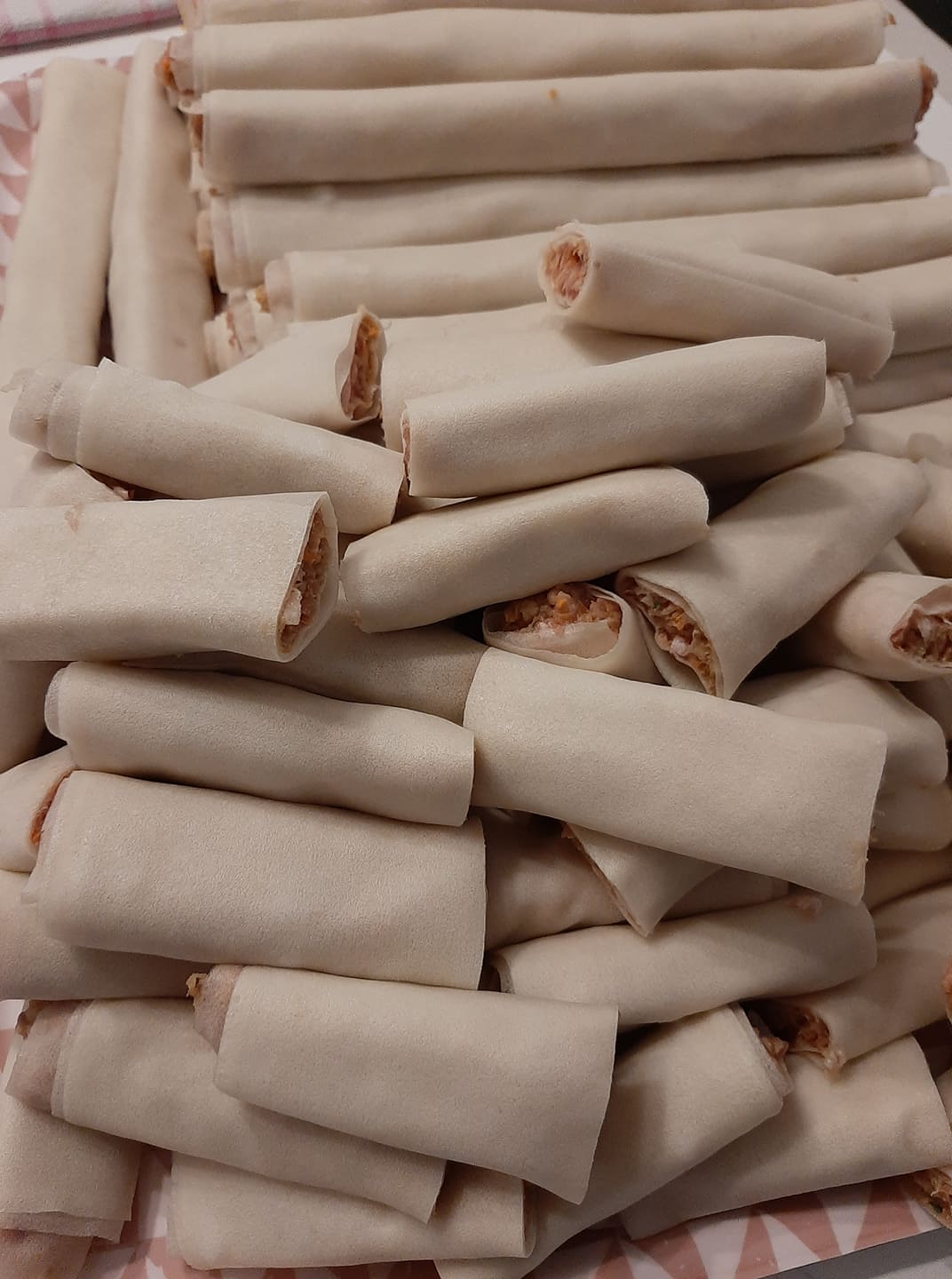 Pile of freshly rolled chicken mini lumpia before cooking