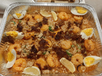 Pancit palabok with shrimp, boiled eggs, lemon and crisp savoury topping