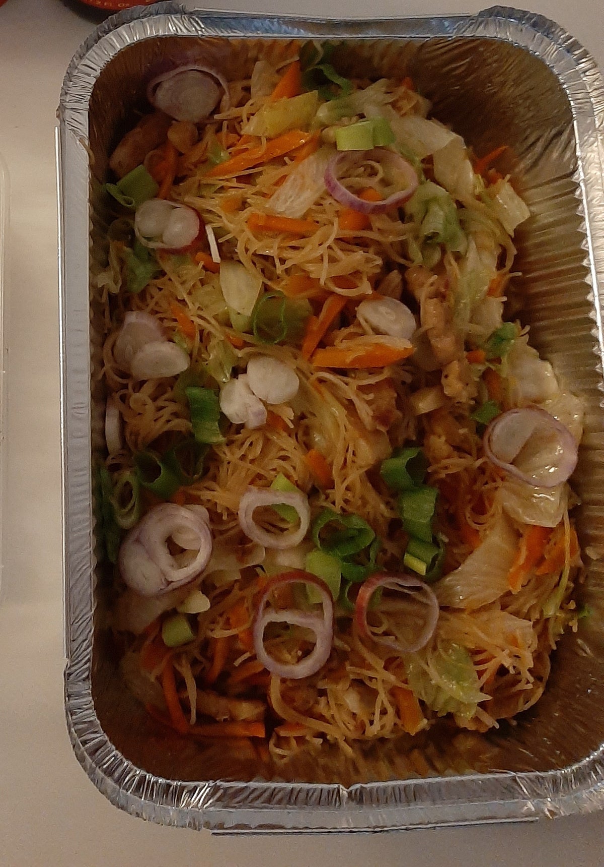 Overhead view of pancit bihon with vegetables, onions and sliced meat