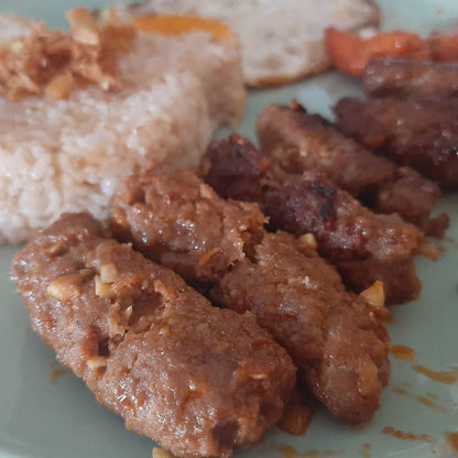 Close-up of sliced chicken longganisa with rice on a plate
