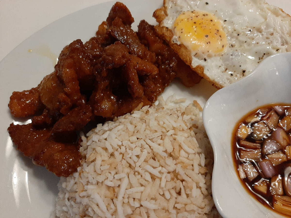 Close-up of glazed chicken tocino served with rice, egg and dipping sauce