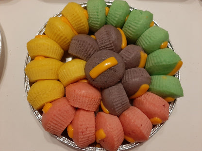 Overhead platter of yellow, green, purple and pink puto cheese