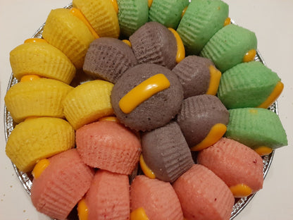 Colourful puto cheese arranged in a round tray with cheese strips
