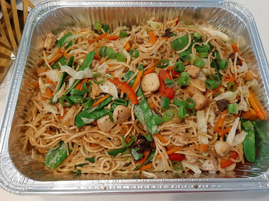 Pancit Canton Guisado with chicken, carrots and snow peas in a foil tray