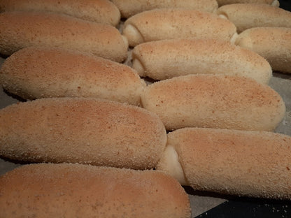 Tray of freshly baked Spanish bread with golden breadcrumb coating