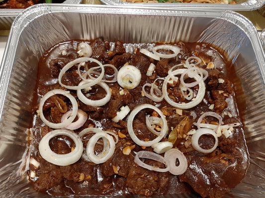 Bistek Tagalog beef in savoury sauce topped with fresh onion rings
