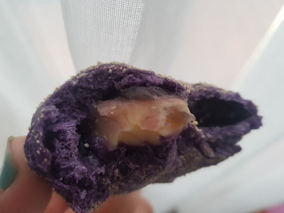 Close-up of halved ube cheese pandesal with creamy cheese filling